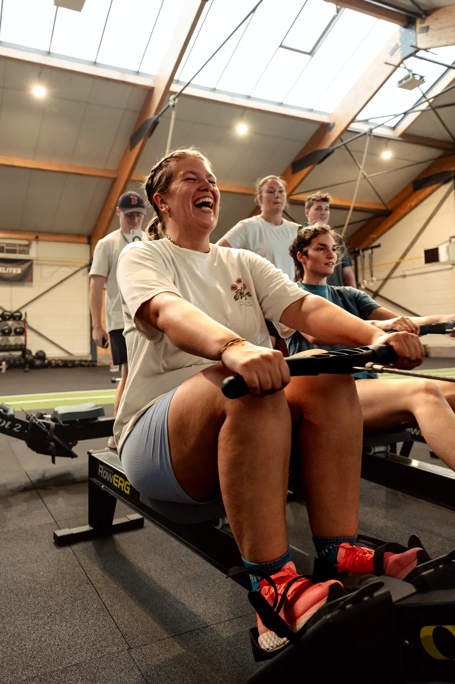 Une membre rit pendant une séance de rameur à CrossFit Heritage